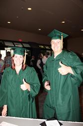 两个澳门新甫京娱乐游戏在线下载的毕业生，戴着绿色的帽子，穿着绿色的长袍.
